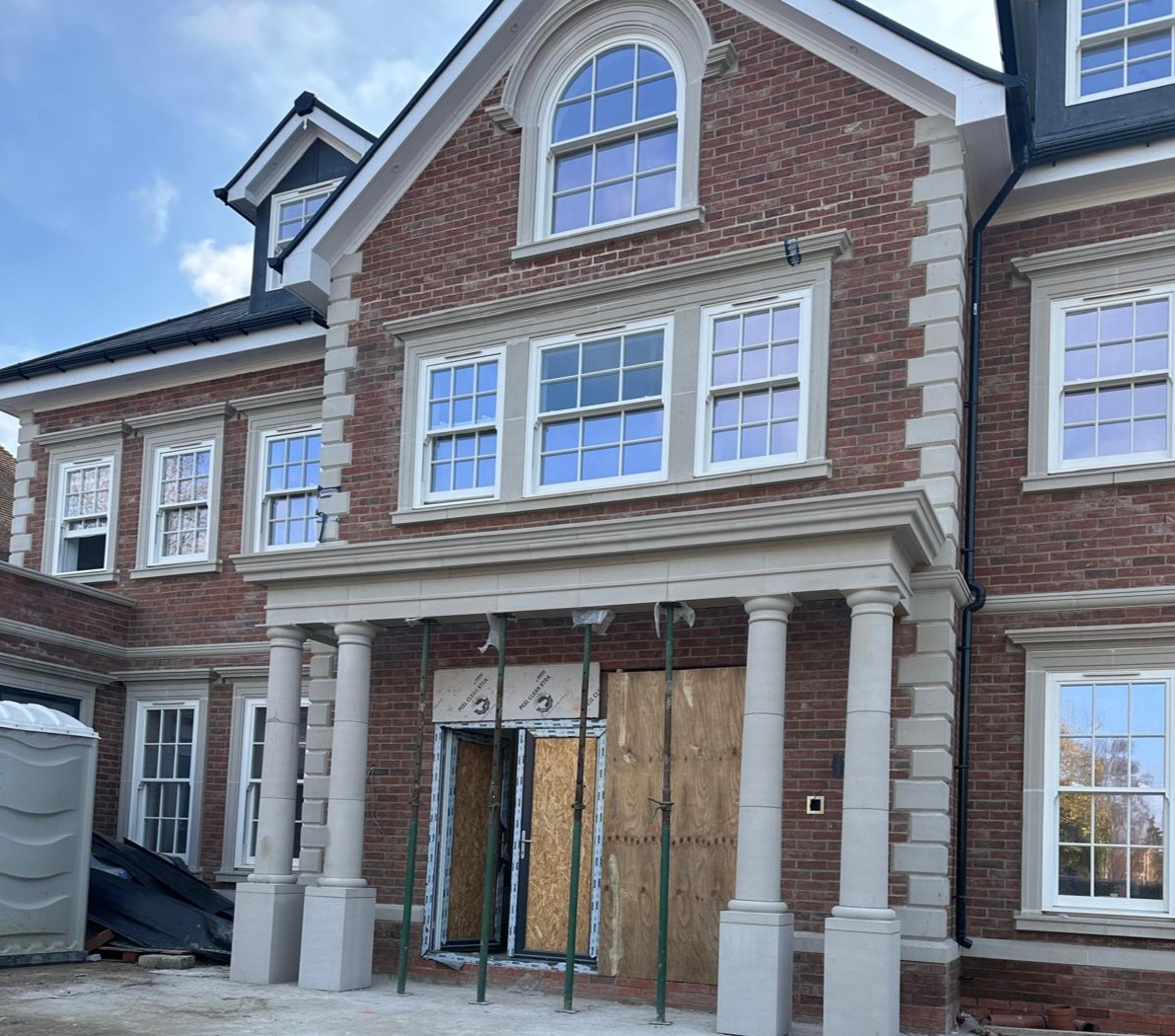 new house on site showing frontage with stone portico and stone quoining details